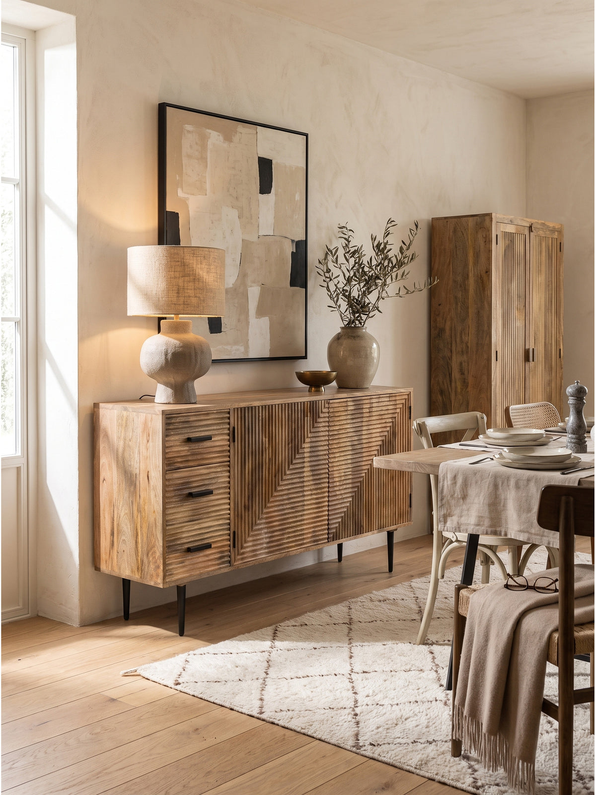 Stilvoll dekoriertes Mango Sideboard mit Tischleuchte, Keramikvase und Kunstwerk im warmen, minimalistischen Wohnzimmer
