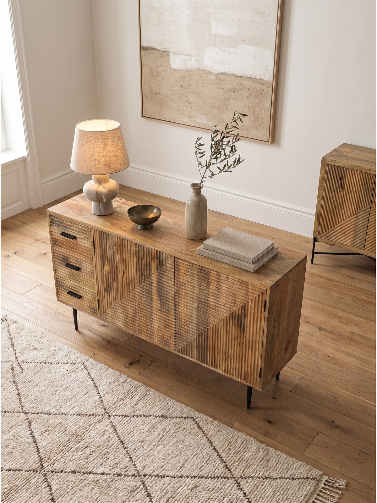 Gefräste Kommode aus Mangoholz von oben fotografiert, 160x40 cm, mit Deko-Vase und Büchern auf der Ablagefläche im hellen Raum_