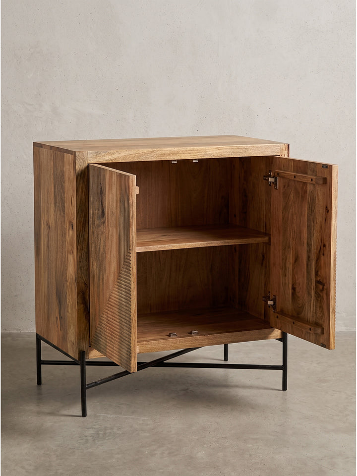 Die natürliche, warme Holzmaserung des Mangoholzes kommt auf der strukturierten Front dieses Design-Sideboards voll zur Geltung_
