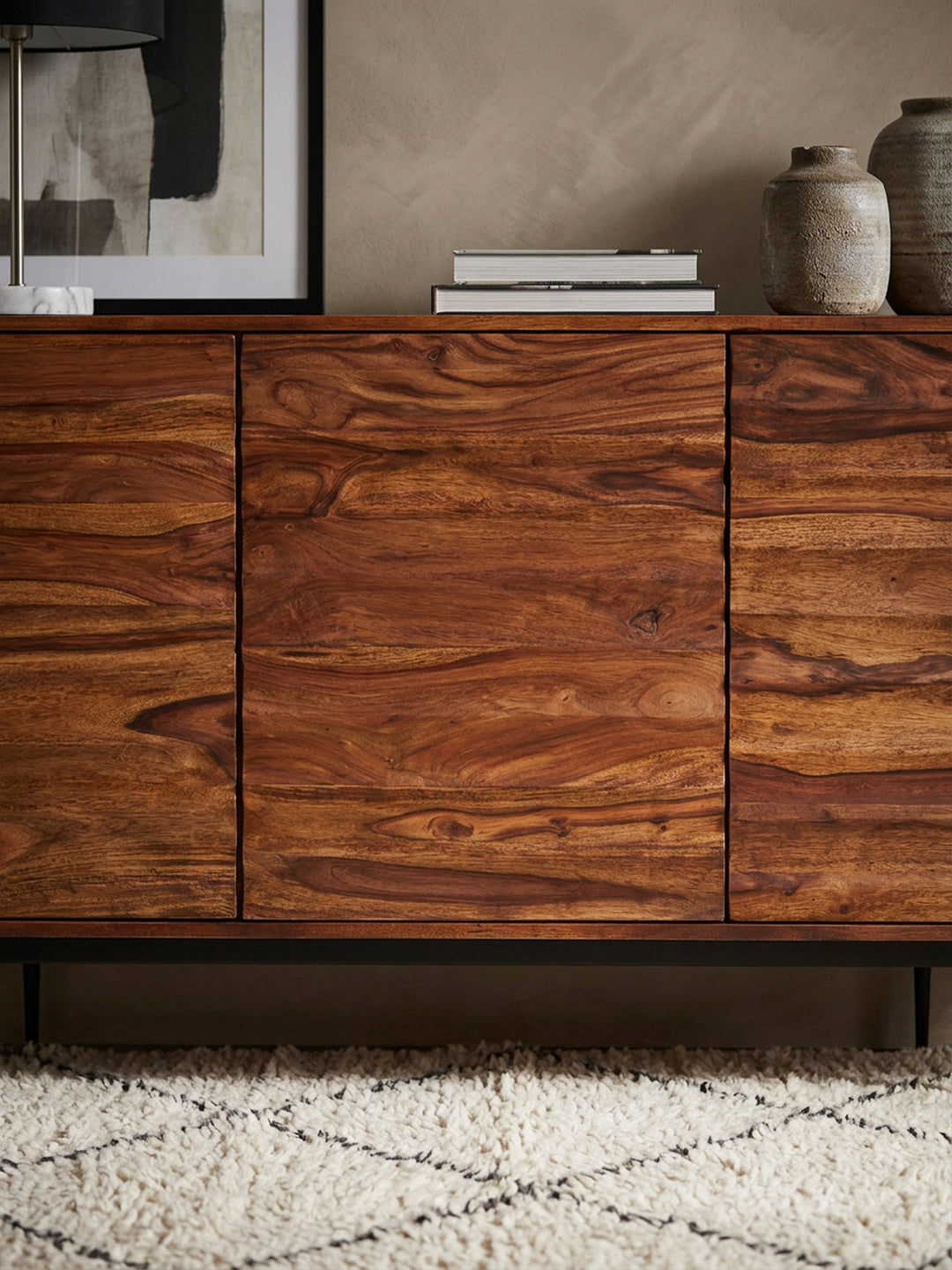 Nahaufnahme der markanten Holzmaserung des Sheesham Sideboards. Die horizontal gewellte 3D-Struktur der massiven Holztüren zeigt warme Brauntöne und präzise handwerkliche Verarbeitung._