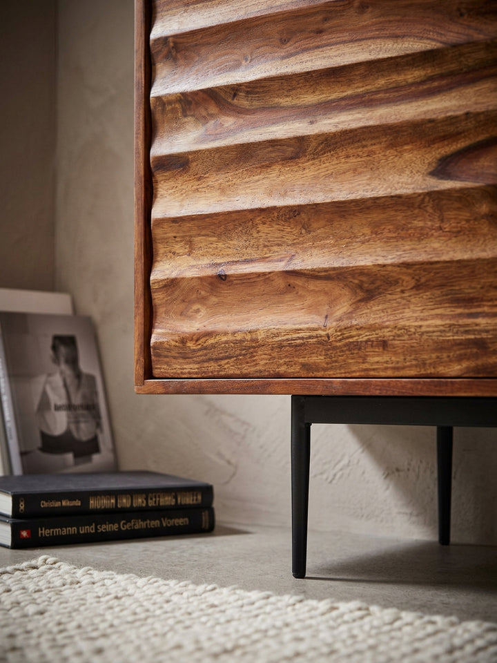 Nahaufnahme der markanten Holzmaserung des Sheesham Sideboards. Die horizontal gewellte 3D-Struktur der massiven Holztüren zeigt warme Brauntöne und präzise handwerkliche Verarbeitung._