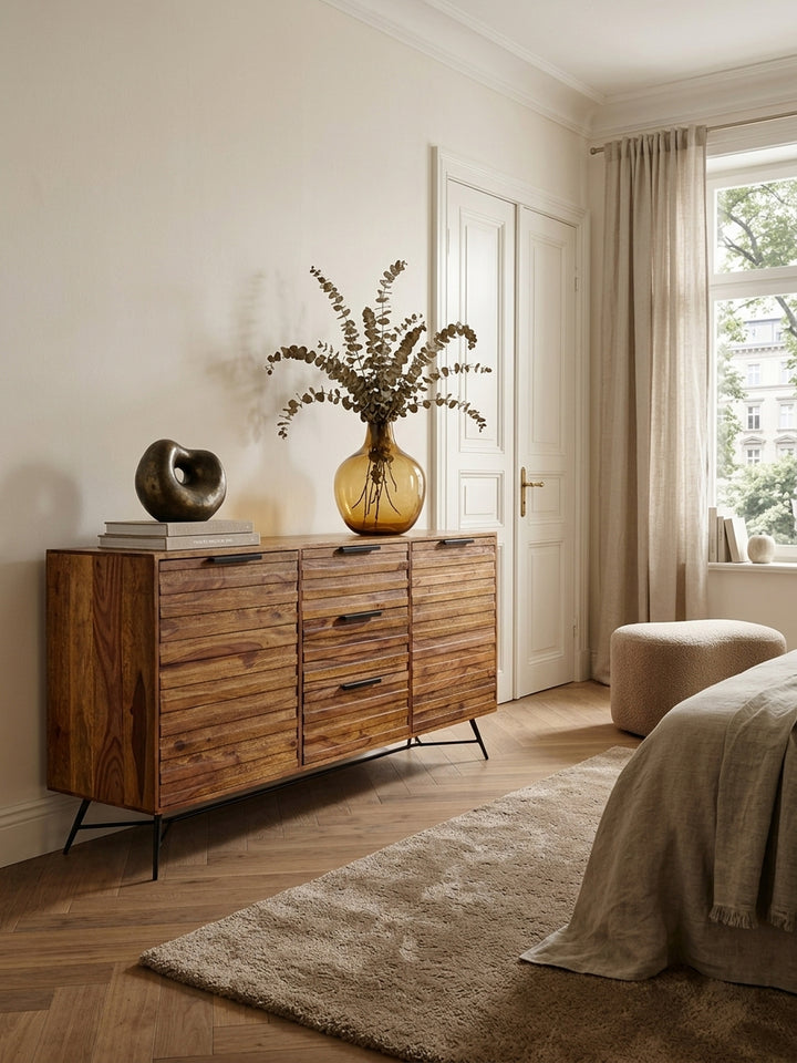 Massives Sheesham Sideboard 160x40x88cm im eleganten Esszimmer. Die warme Holzmaserung und schwarze Metallbeine harmonieren perfekt mit einem hellen Wollteppich und dezenter Wandgestaltung._