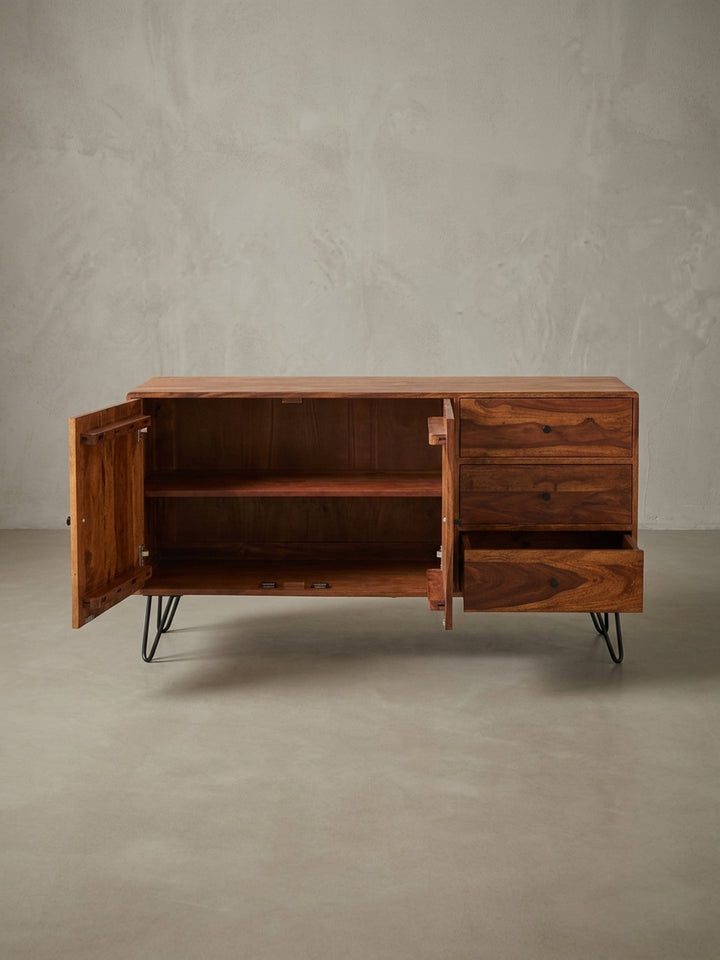 Perspektivische Darstellung einer Wohnzimmer Kommode aus dunklem Echtholz. Das Zusammenspiel aus rustikalem Holz und schwarzen Metall-Elementen prägt das moderne Industriedesign._