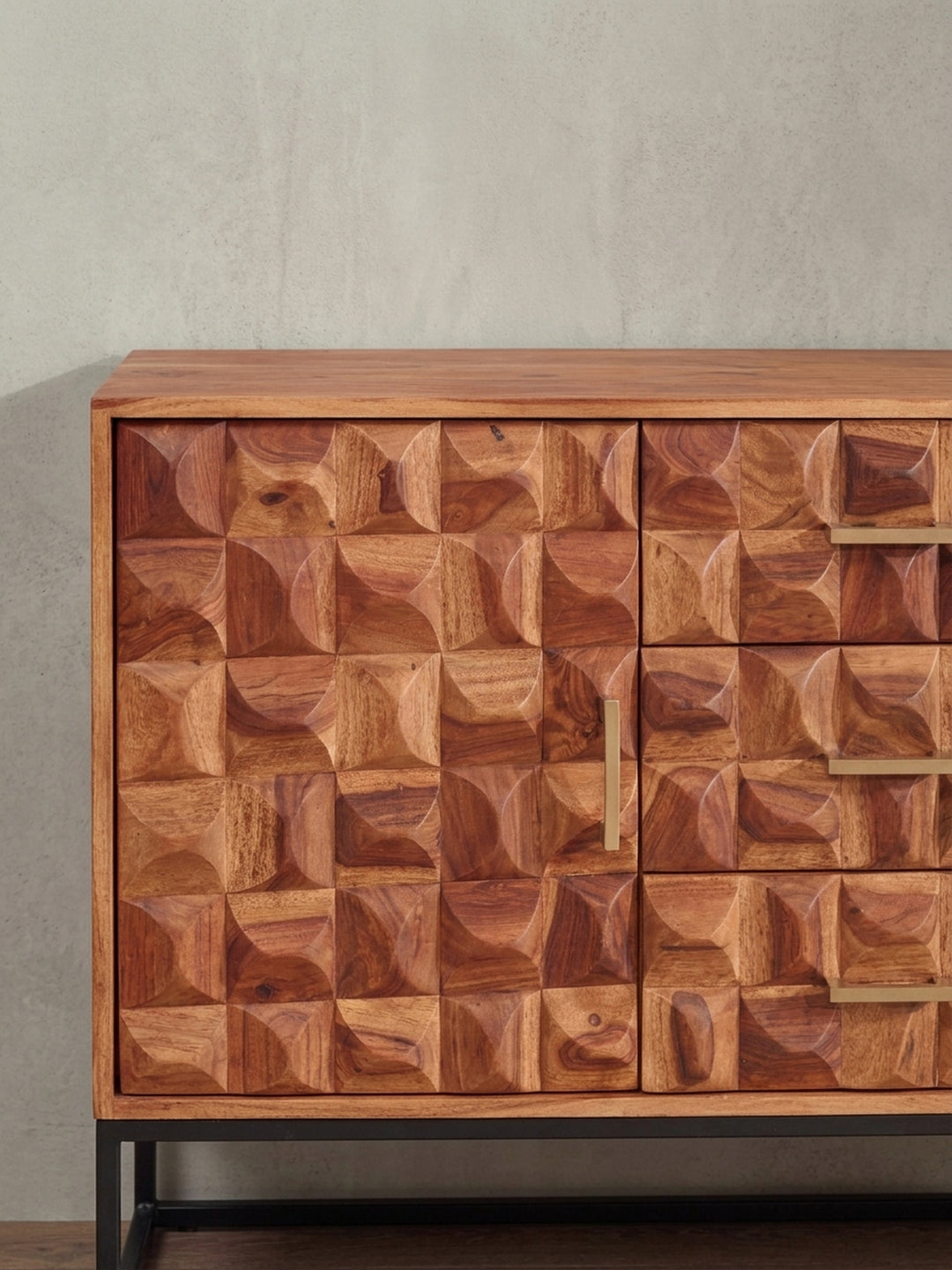 Detailaufnahme eines goldenen Metallgriffs auf der strukturierten 3D-Front der Kommode, die den Kontrast zwischen rauem Holz und glattem Metall zeigt._