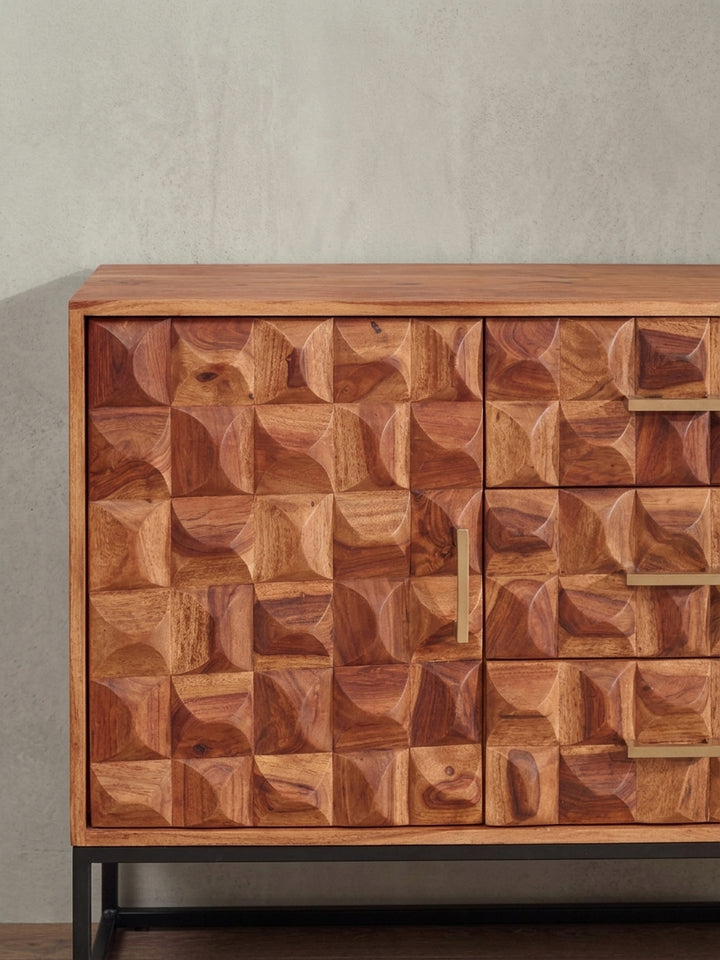 Detailaufnahme eines goldenen Metallgriffs auf der strukturierten 3D-Front der Kommode, die den Kontrast zwischen rauem Holz und glattem Metall zeigt._