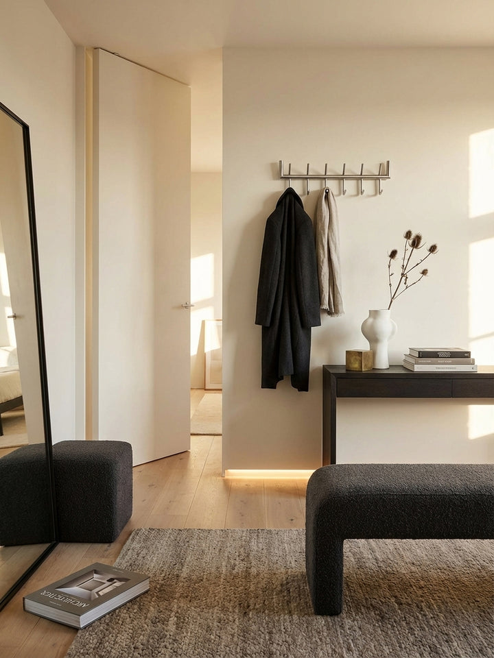 Makroaufnahme der Oberfläche der Design Wandgarderobe, die die feine Textur des matt polierten Stahls und die hochwertige Verarbeitung der Schweißnähte zeigt._