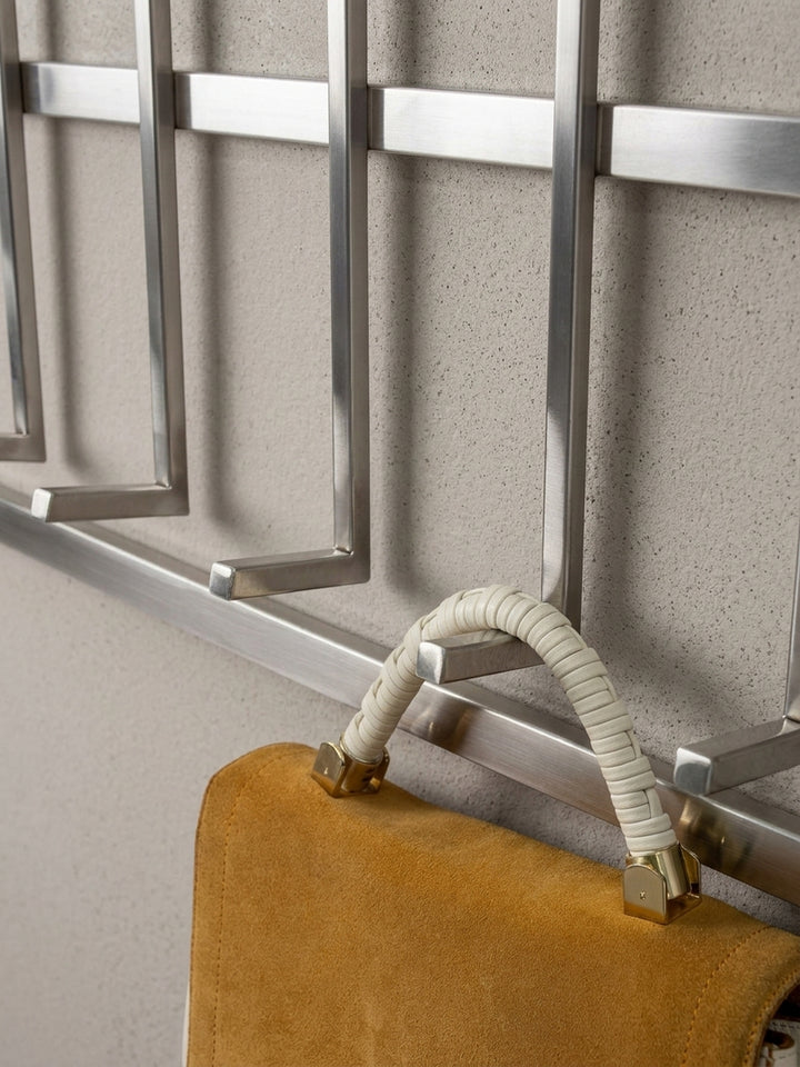 Nahaufnahme eines einzelnen Garderobenhakens aus gebürstetem Stahl, der die präzise Formgebung und die Stabilität für schwere Mäntel verdeutlicht._