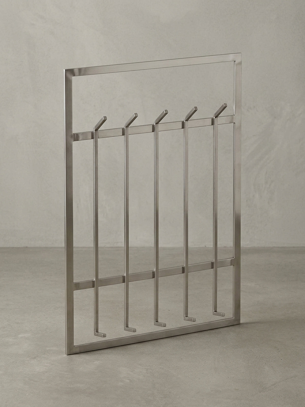 Gesamtansicht der silbernen Design-Garderobe, die ihre architektonische Formensprache und die Funktionalität für einen organisierten Eingangsbereich zusammenfasst.