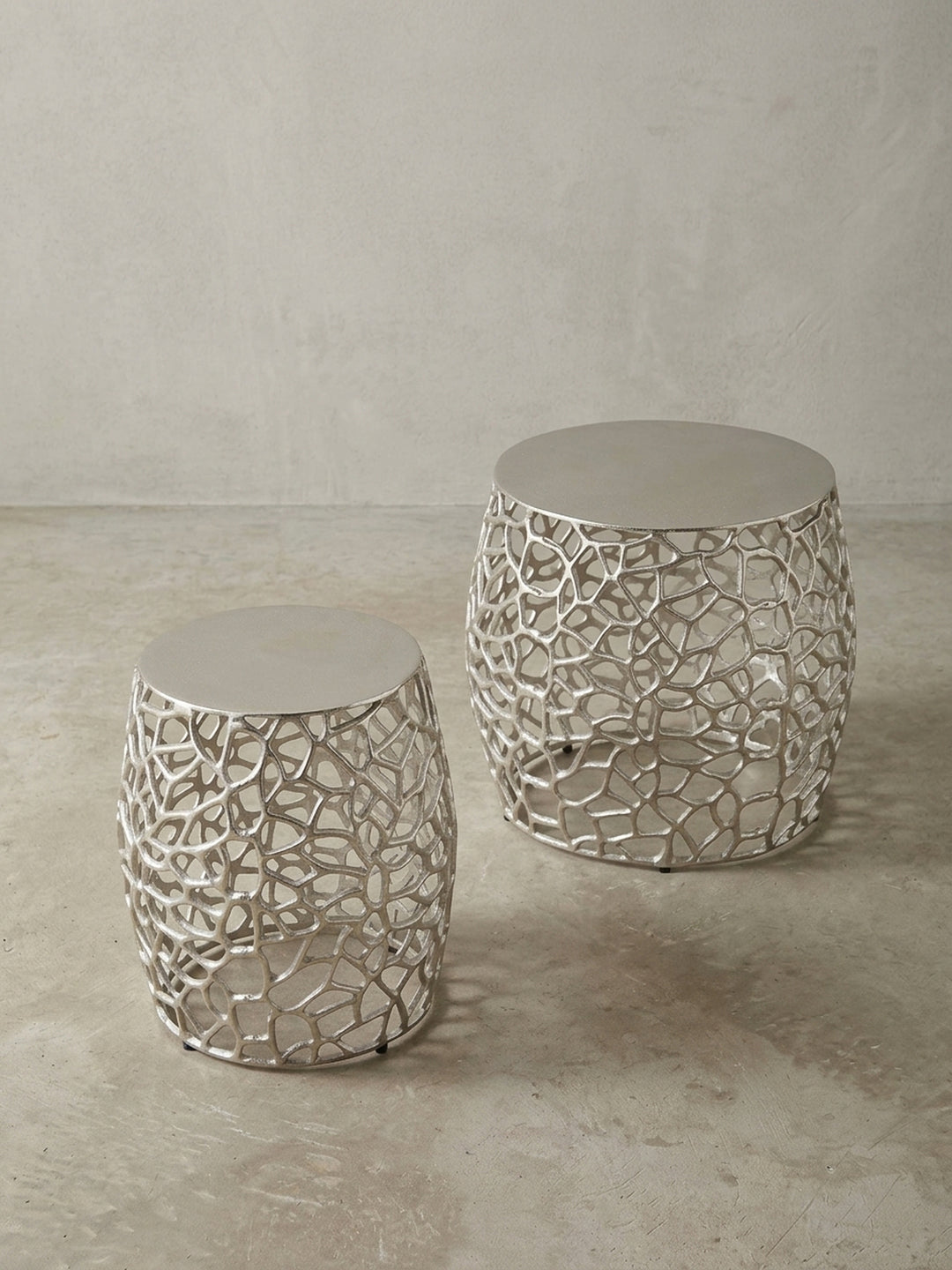 Makroaufnahme der Verbindung zwischen der soliden Aluminium-Tischplatte und dem filigranen, silbernen Gestell des modernen Sofatisches._