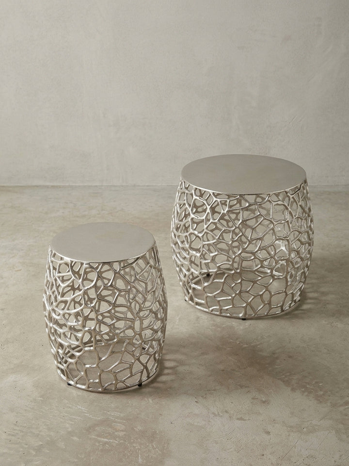 Makroaufnahme der Verbindung zwischen der soliden Aluminium-Tischplatte und dem filigranen, silbernen Gestell des modernen Sofatisches._