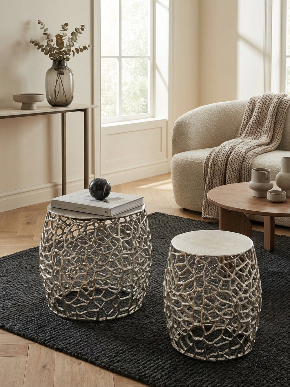 Die runden Satztische mit Ast-Struktur von oben betrachtet, zeigen ihre harmonische Anordnung auf einem Holzboden und ihre Funktion als flexible Ablage._