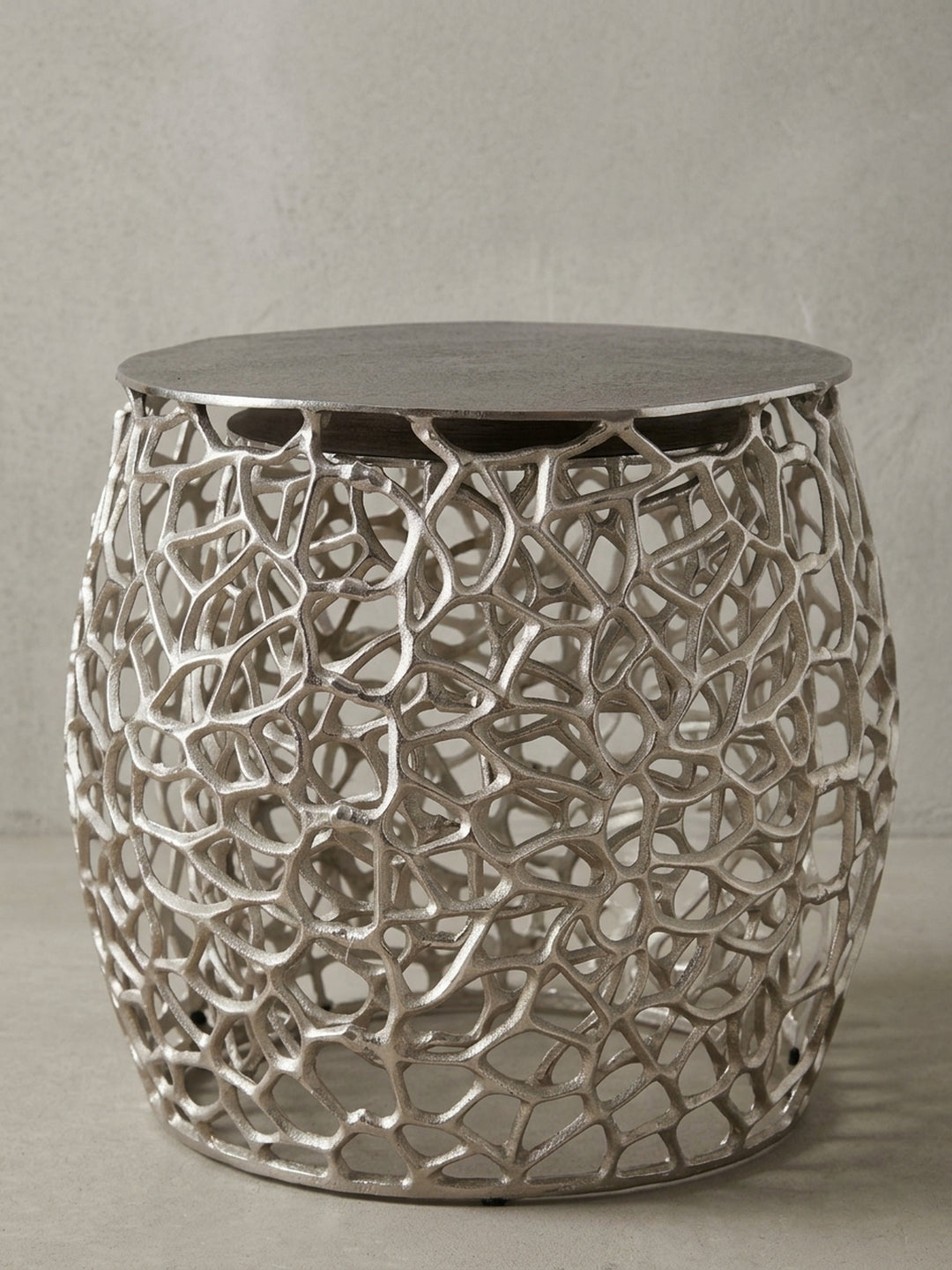 Der größere Design-Couchtisch (46cm breit) aus einer leicht erhöhten Perspektive, die die runde, massive Tischplatte im Kontrast zum leichten Gestell betont._