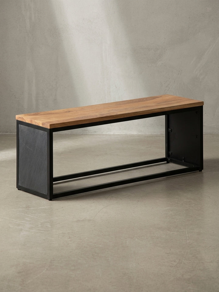 Minimalistische Sitzbank mit einer 120 cm breiten Sitzfläche aus massivem Akazienholz und einem stabilen schwarzen Gestell, freigestellt vor weißem Hintergrund._