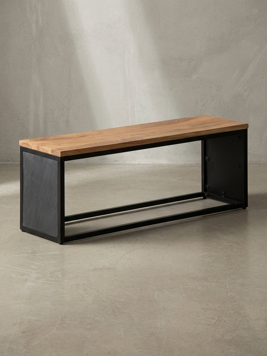Minimalistische Sitzbank mit einer 120 cm breiten Sitzfläche aus massivem Akazienholz und einem stabilen schwarzen Gestell, freigestellt vor weißem Hintergrund._