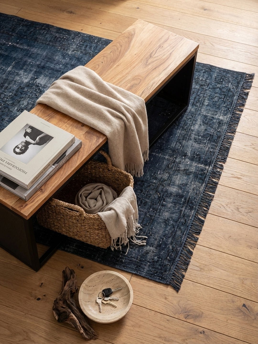 Sitzbank aus Holz und Metall von oben betrachtet, positioniert auf einem Vintage-Teppich im Flur, zeigt die schlanke und funktionale Silhouette des Möbelstücks._