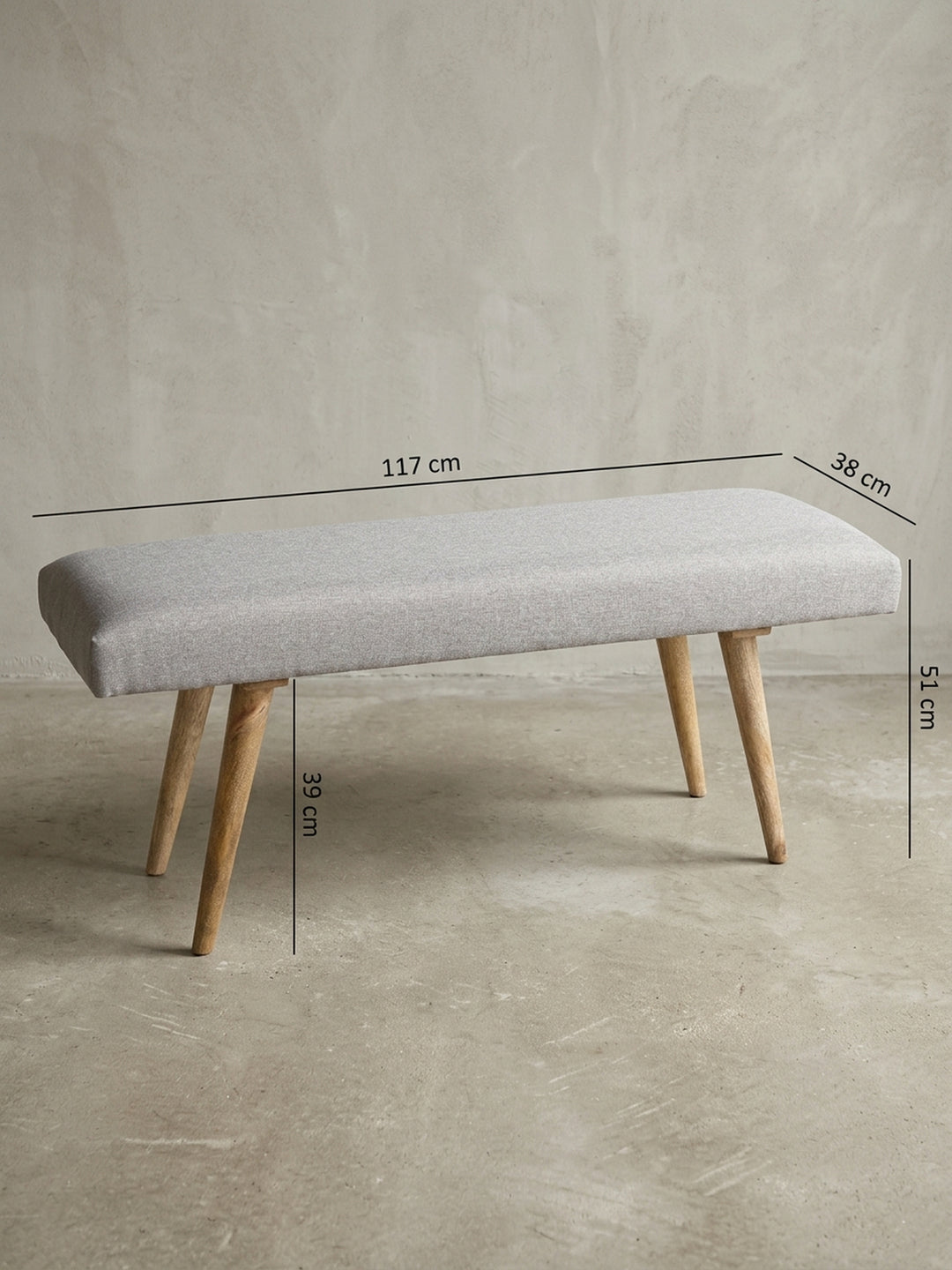 Rückwärtige Detailansicht der grauen Bettbank im Retro-Design. Die saubere Verarbeitung des Baumwollbezugs und die stabile Befestigung der ausgestellten Mangoholzbeine garantieren_