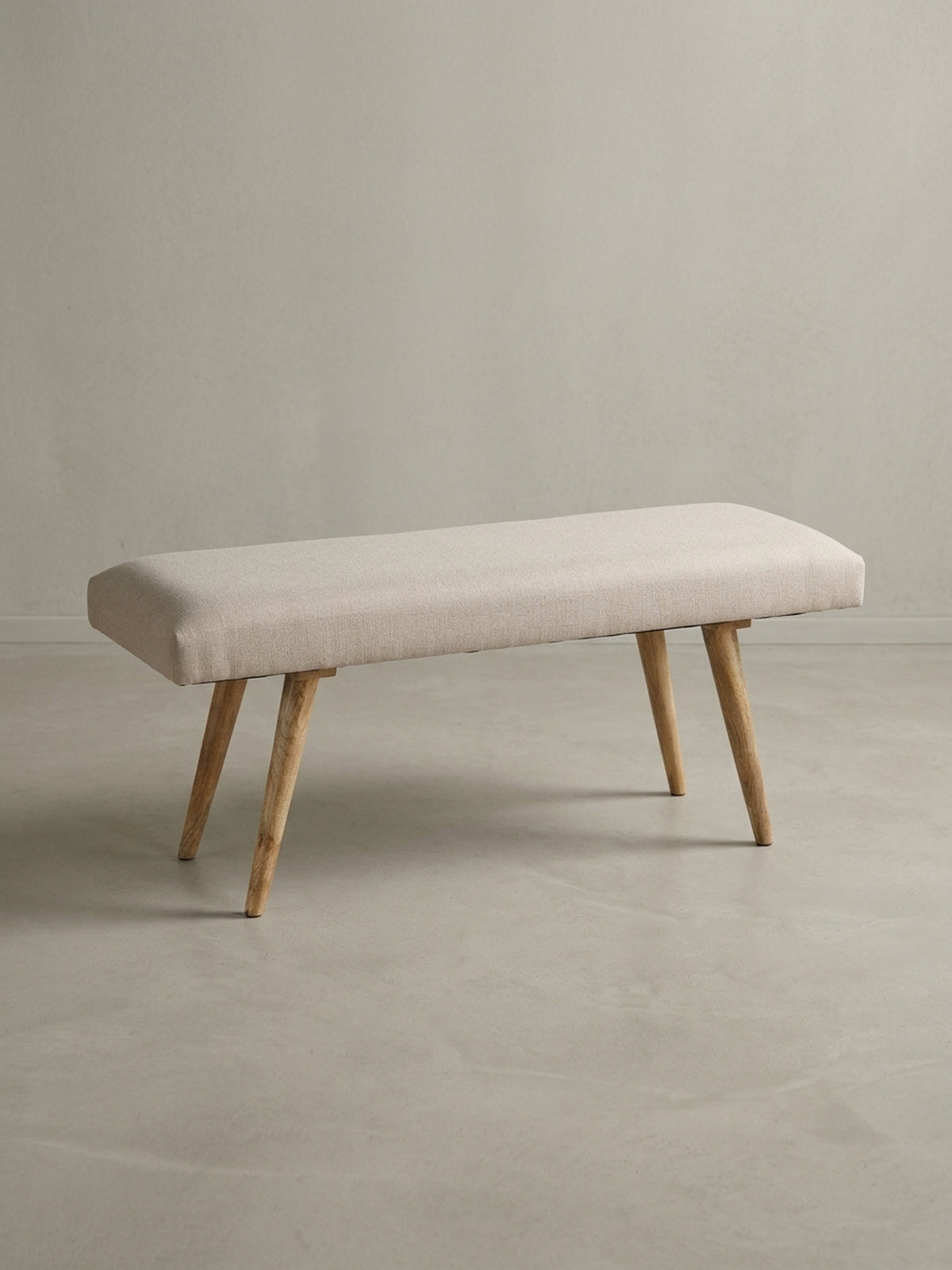 Alternative Perspektive der Esszimmerbank in Beige. Der helle Baumwollstoff spannt sich faltenfrei über das Polster, während die 39 cm Bodenfreiheit optische Leichtigkeit schafft._