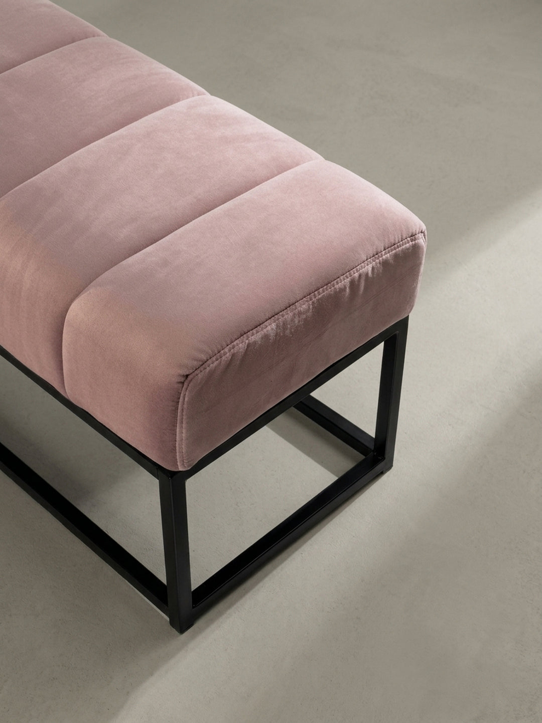 Perspektivische Ansicht der rosa Samtbank von oben, die das Muster der sieben gesteppten Kanäle auf der Sitzfläche detailliert darstellt._