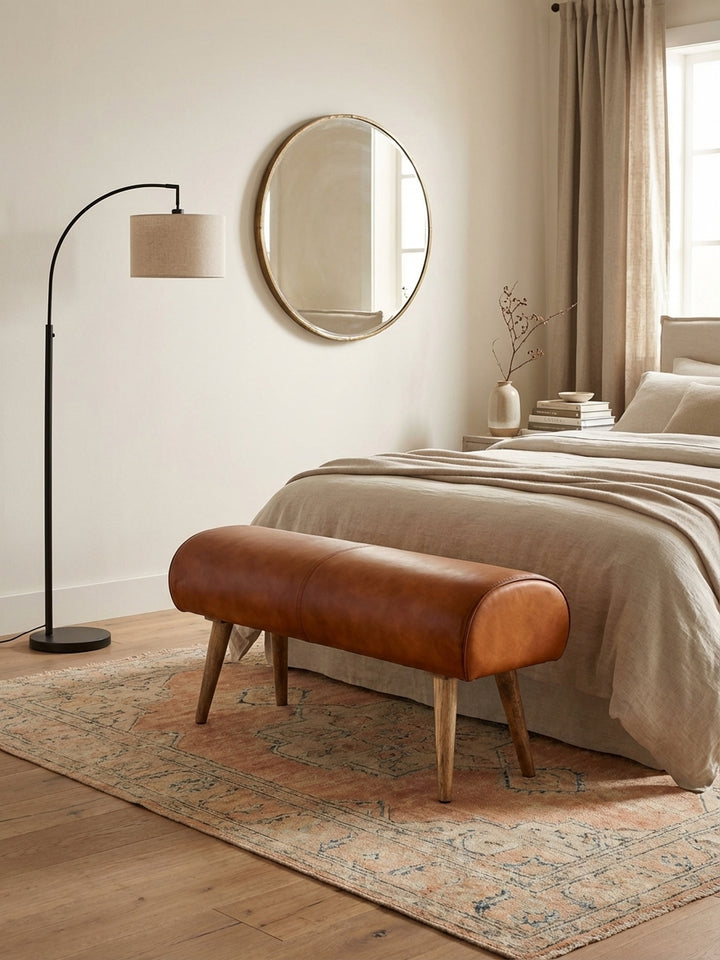 Design-Komposition von oben: Die 100 cm lange Turnbock-Bank aus Leder und Massivholz arrangiert in einem Flur mit Eichenparkett und Designer-Teppich._