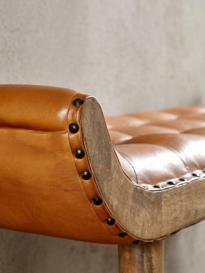 Alternative Perspektive auf die Chesterfield Bank, die den Glanz des Echtleders und die Maserung des massiven Mangoholzes betont. Ideal als Bettbank im Schlafzimmer._