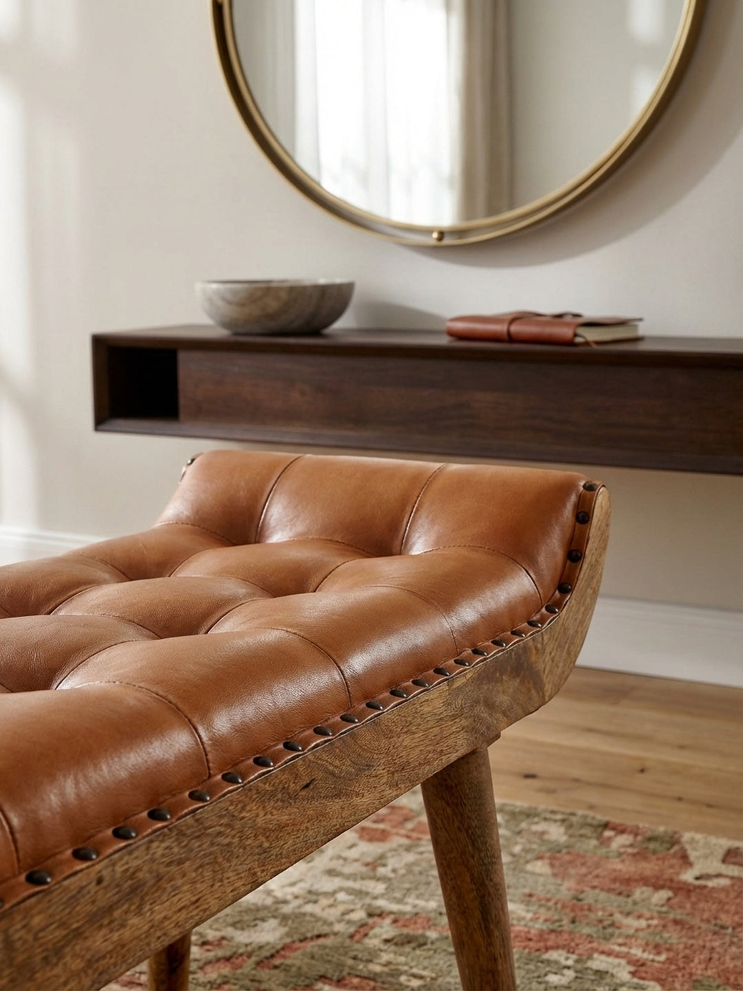 Makroaufnahme der weichen Ziegenleder-Oberfläche der braunen Sitzbank. Die feine Narbung und die handwerkliche Chesterfield-Steppung sind im Detail sichtbar._