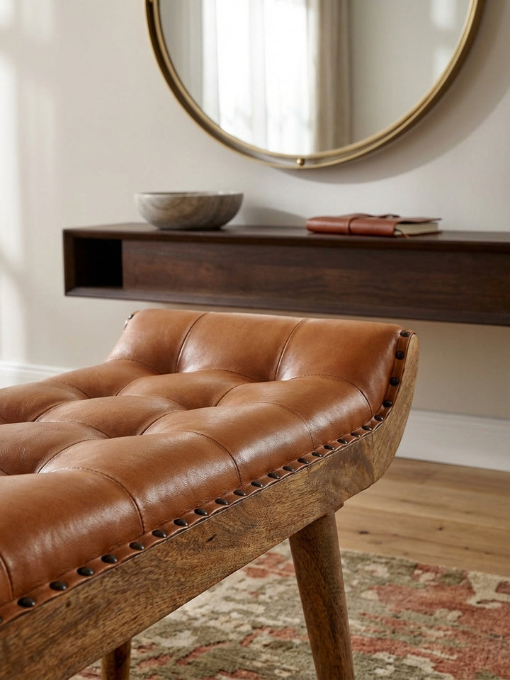Makroaufnahme der weichen Ziegenleder-Oberfläche der braunen Sitzbank. Die feine Narbung und die handwerkliche Chesterfield-Steppung sind im Detail sichtbar._