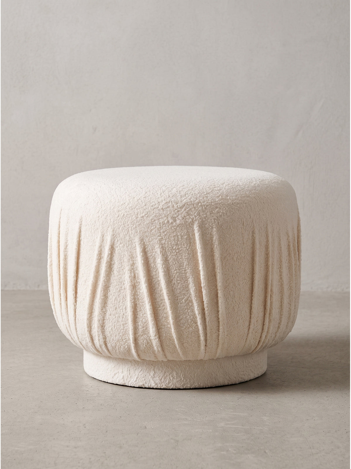 Handmade Polsterhocker Faltenoptik Creme im Seitenprofil zeigt die elegante Rundung und die weiche Oberfläche des Stoffs