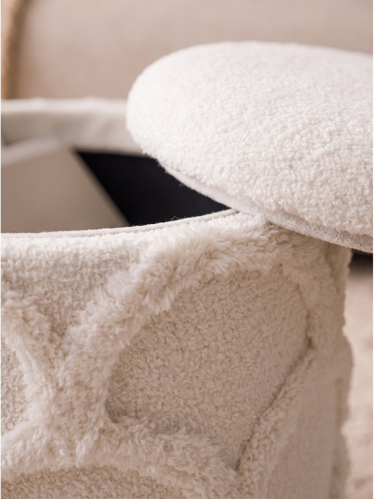 Detailaufnahme des flauschigen Teddy Stoffes am Hocker mit markantem Reliefmuster im sanften Nachmittagslicht_