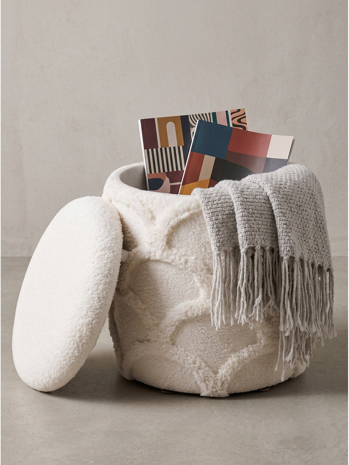 Kompakter Hocker 40cm rund aus weichem Teddyfutter creme weiß mit gepolstertem Deckel freigestellt vor weißem Hintergrund