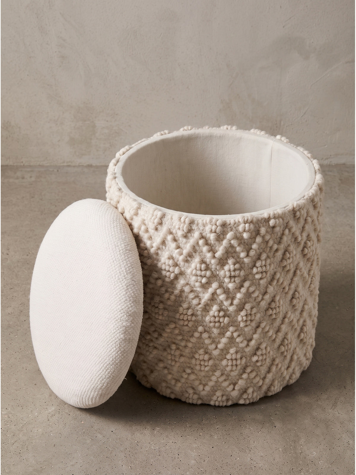 Cremefarbener Struktur-Hocker im Boho-Stil 40x45 cm in der schrägen Seitenansicht mit abgenommenem Polsterdeckel