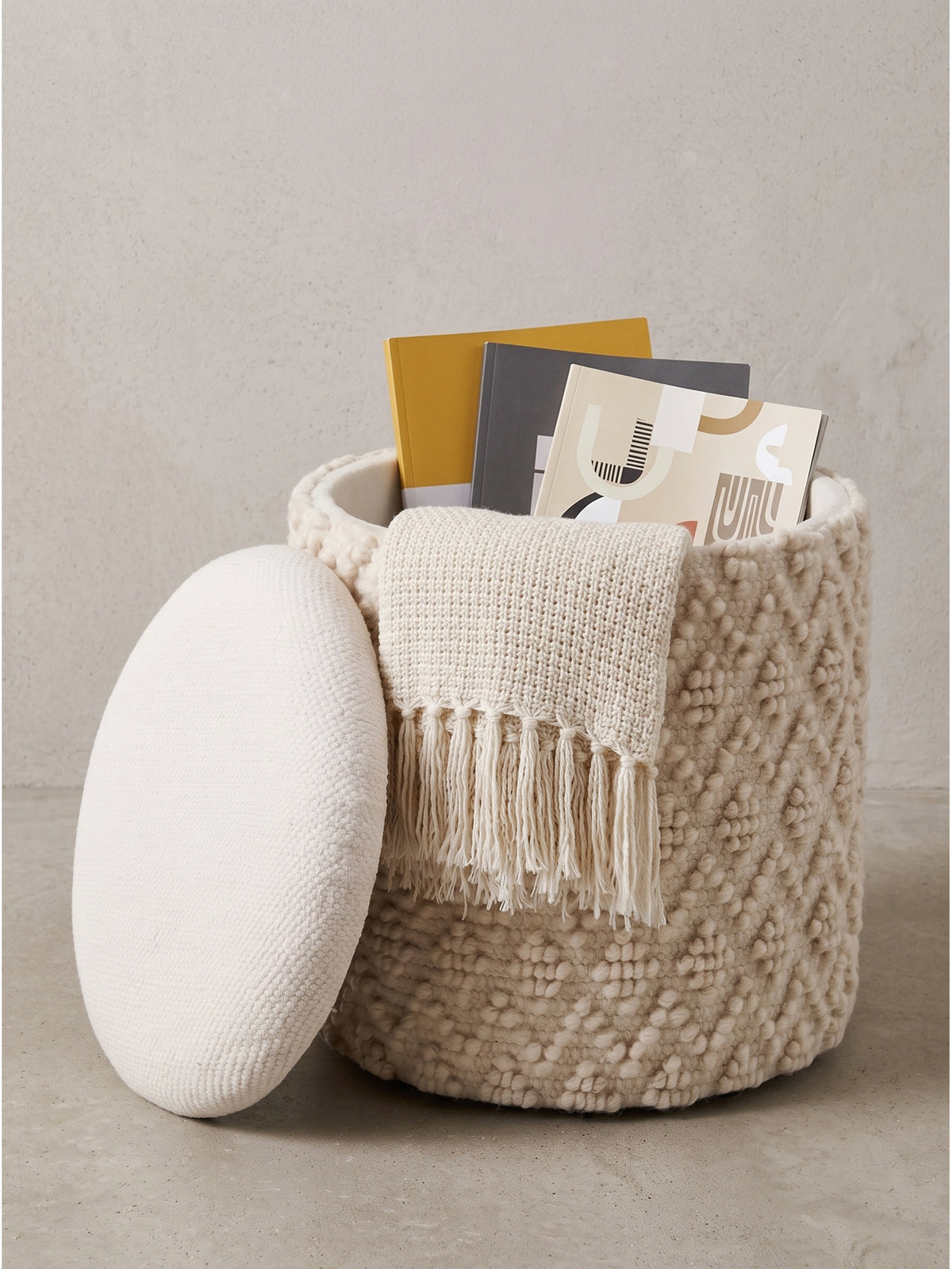 Runder Sitzhocker mit Stauraum in Creme 40x45 cm aus weichem Wollstoff mit geöffnetem, glatt gepolstertem Deckel