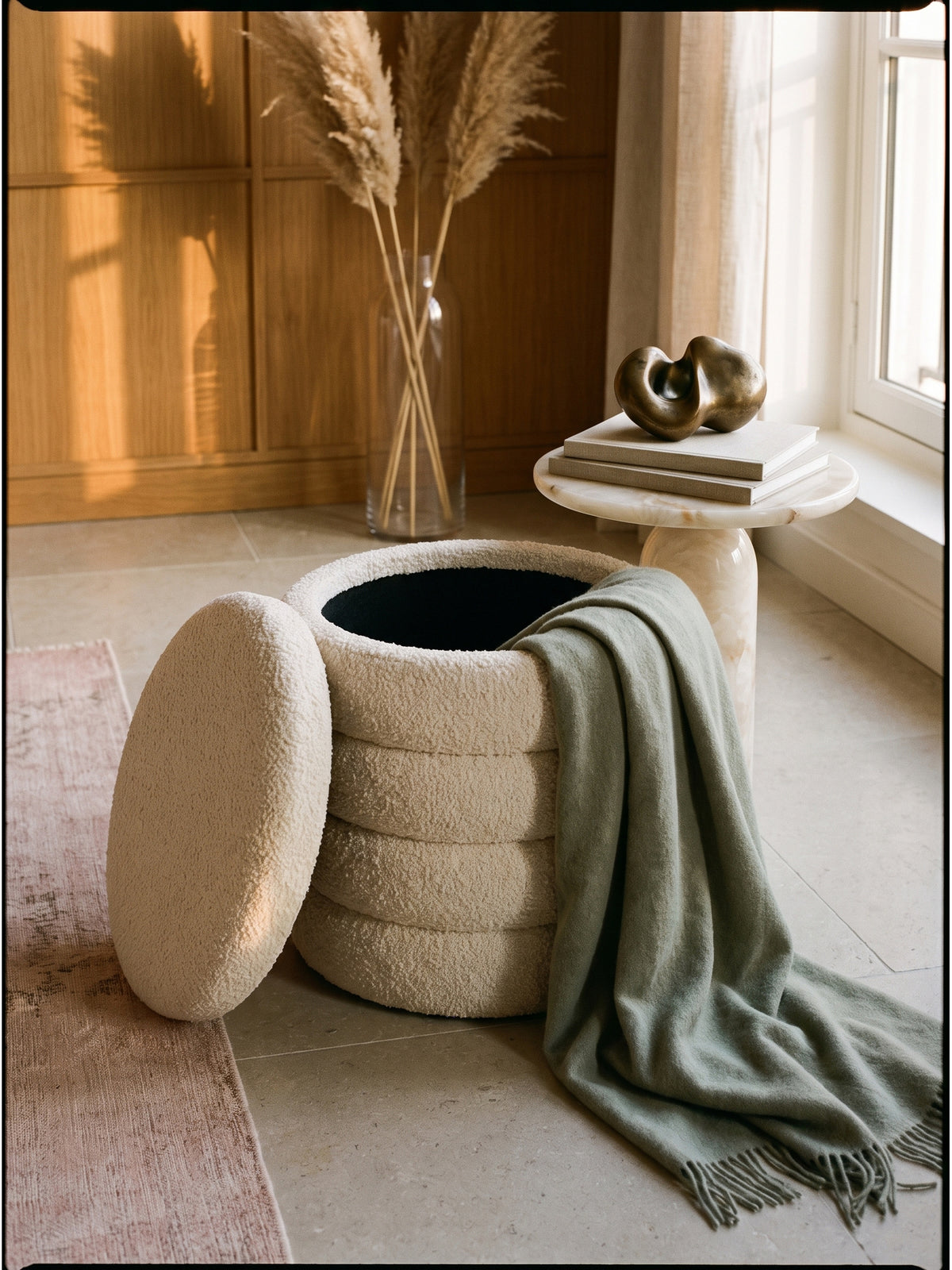 Eleganter Schminktisch Hocker aus Teddystoff dekoriert mit einer gestrickten Kuscheldecke und Magazinen_