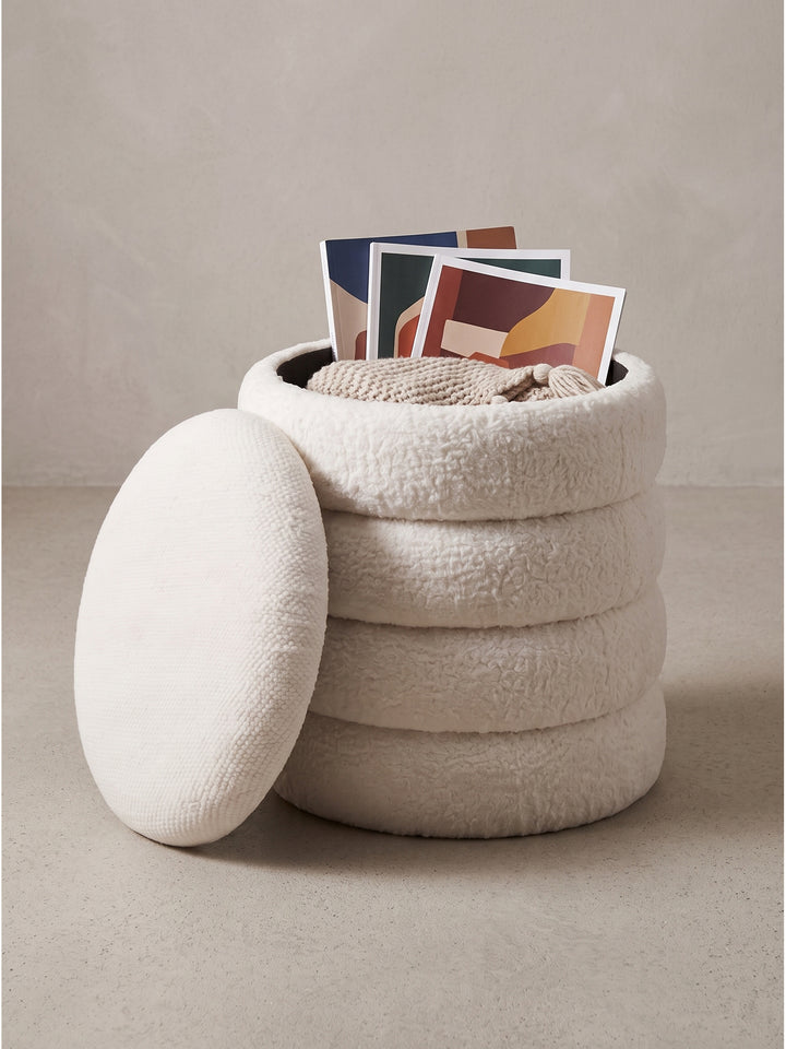 Cremefarbener Sitzhocker mit Stauraum leicht schräg fotografiert zeigt das weiche Polster Design vor weißem Hintergrund_