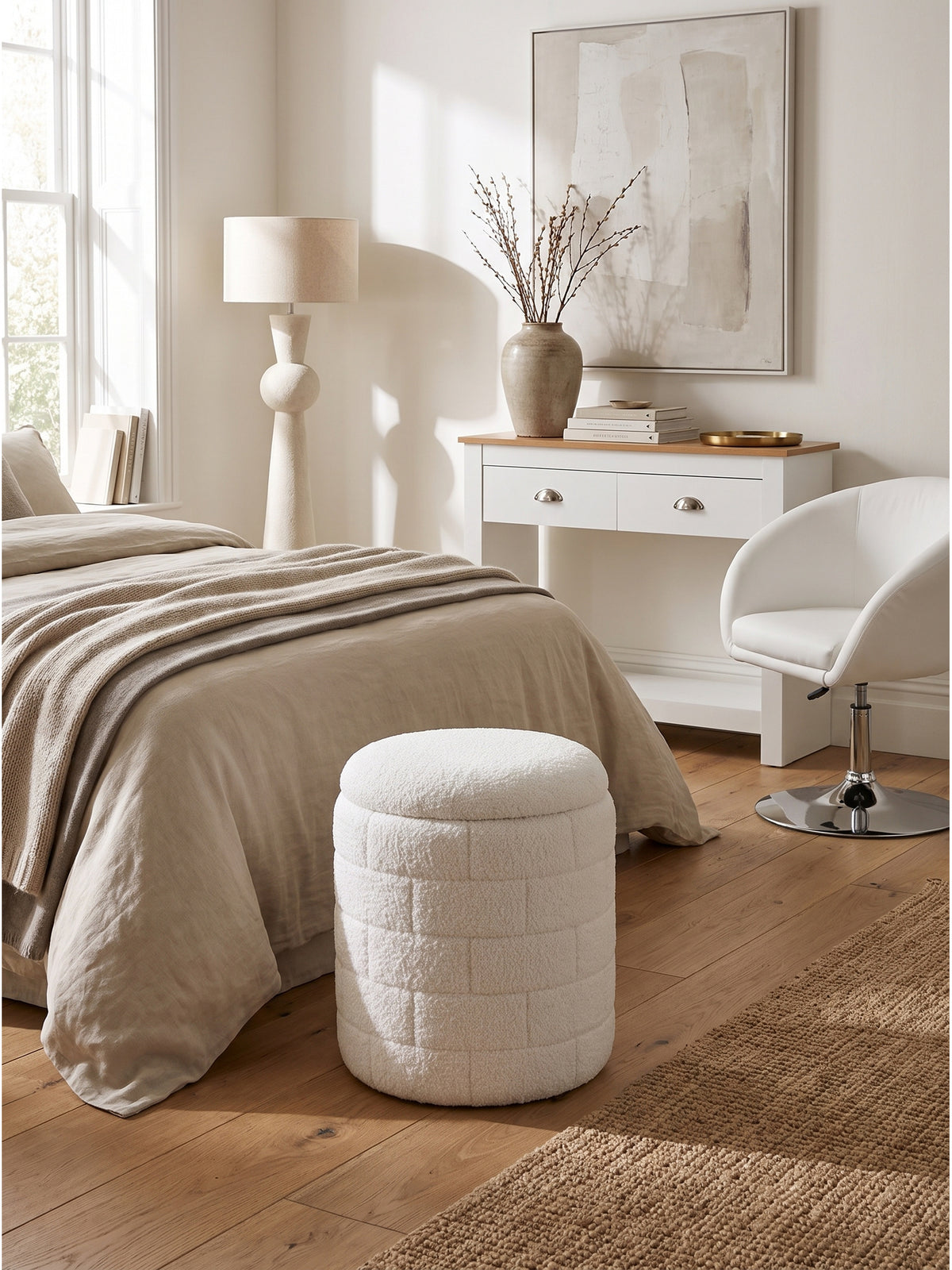 Harmonische Kombination aus dem runden weißen Stoffhocker und einem flachen Couchtisch aus hellem Holz im minimalistisch eingerichteten Raum_