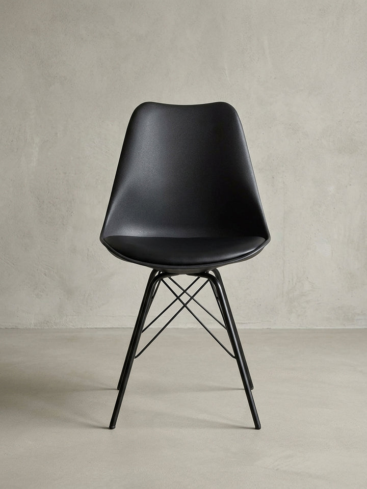 Zwei schwarze Esszimmerstühle als 2er-Set aus einer dynamischen Perspektive, die sich ideal für die moderne Küchen- oder Esszimmereinrichtung eignen._