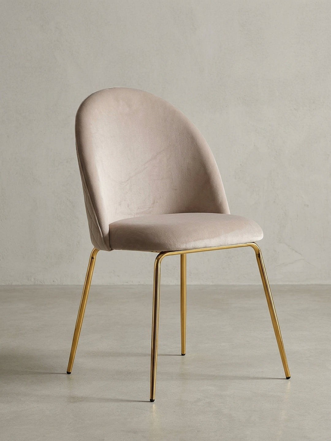 Design-Schalenstuhl in Beige mit goldfarbenem Metallgestell in der 3/4-Ansicht, die die geschwungene Rückenlehne hervorhebt._
