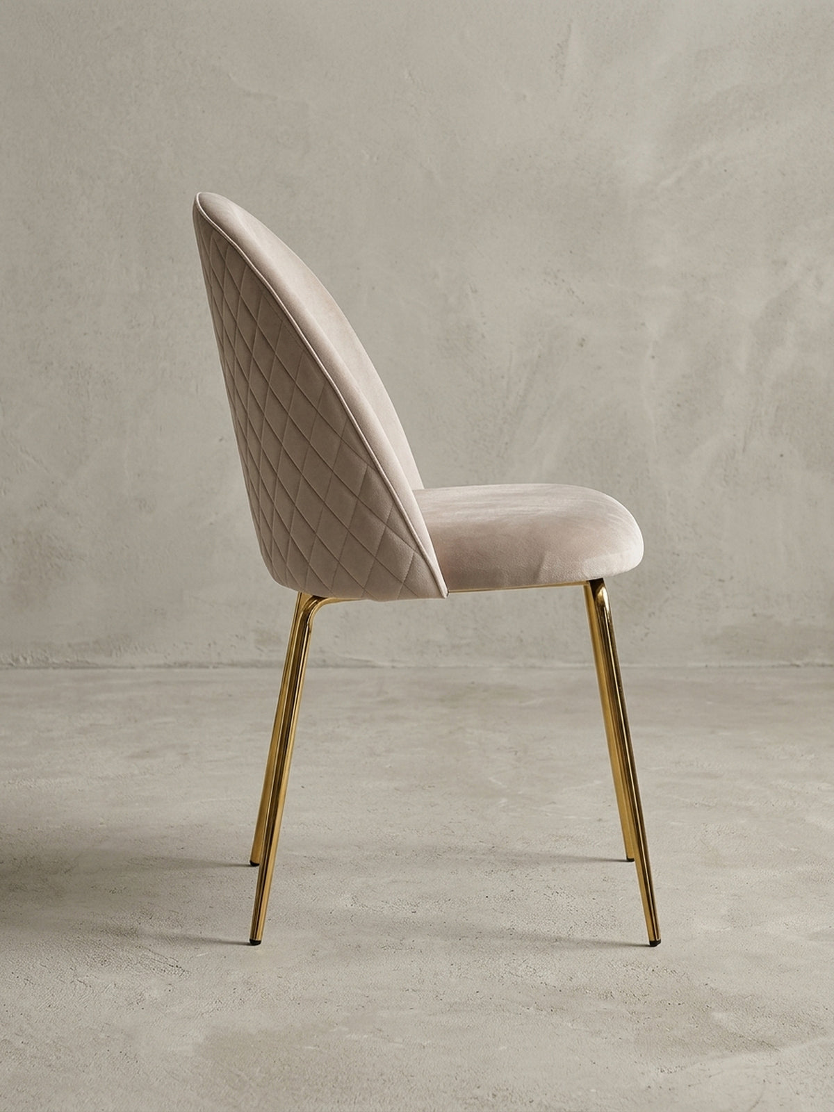 Gepolsterter Samt-Stuhl in Beige in einer dynamischen Perspektive, die das Zusammenspiel von weichem Stoff und glänzendem Metall betont._