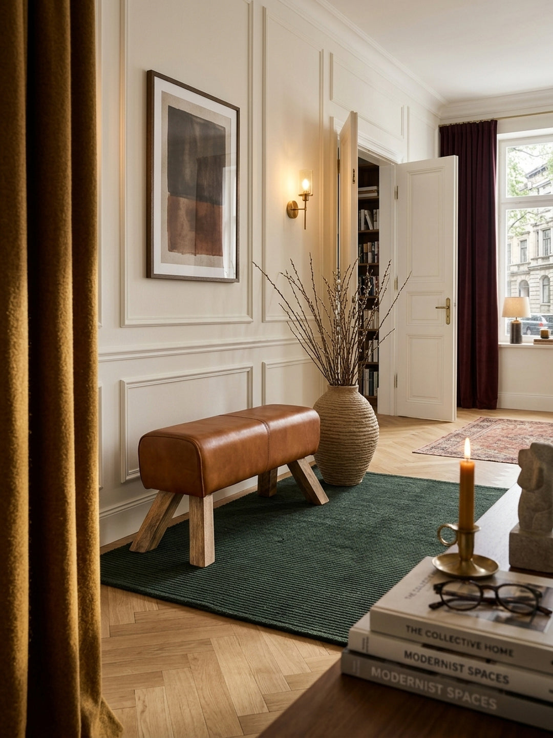 Elegante Lederbank im Vintage Turnbock Design im luxuriösen Flur mit Fischgrätparkett. Cognacbraunes Ziegenleder und Mangoholz Beine als stilvoller Blickfang im Eingangsbereich._
