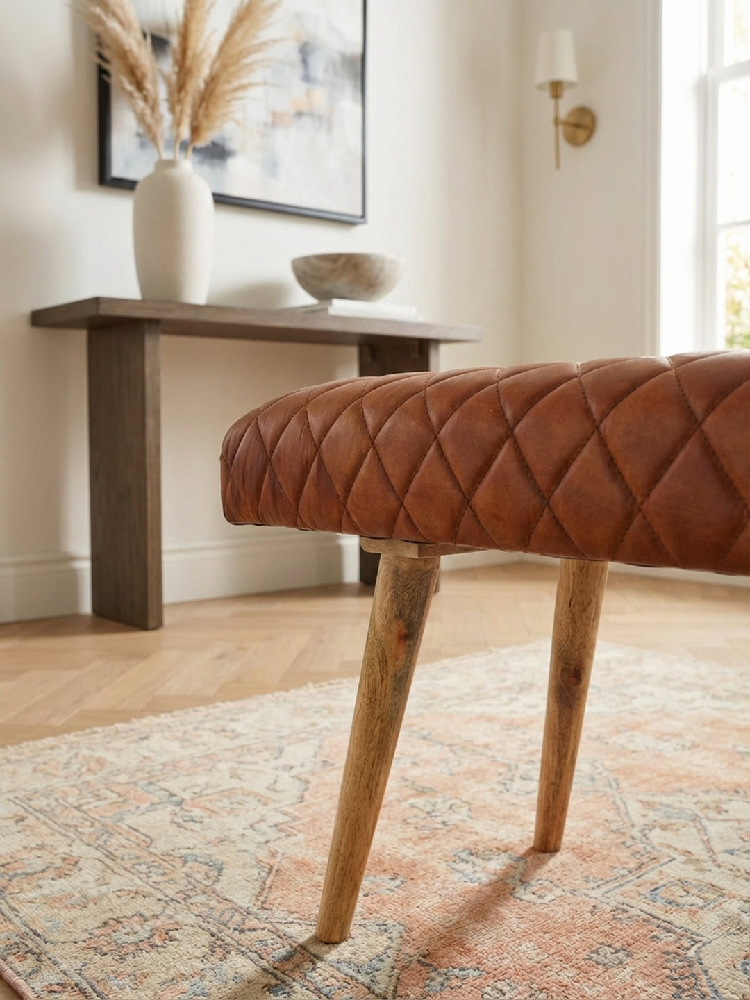 Detailaufnahme der weichen Haptik der braunen Echtleder-Sitzbank mit präziser Rautensteppung. Die hochwertige Verarbeitung des Leders ist deutlich erkennbar._