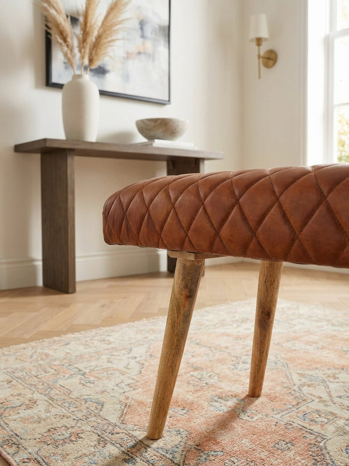 Detailaufnahme der weichen Haptik der braunen Echtleder-Sitzbank mit präziser Rautensteppung. Die hochwertige Verarbeitung des Leders ist deutlich erkennbar._