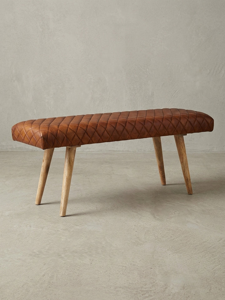 Gesamtansicht der Design-Sitzbank, die das zeitlose Design durch die Kombination von gestepptem Echtleder und massivem Mangoholz zusammenfasst._