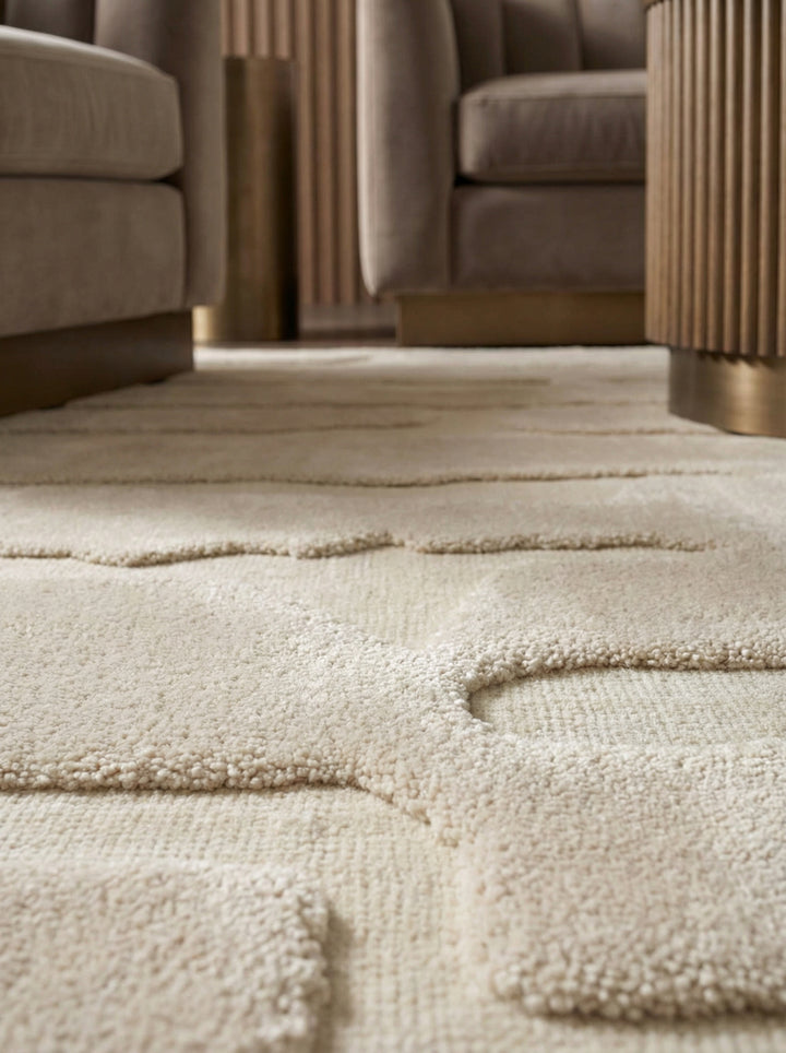 Nahaufnahme eines elfenbeinfarbenen Teppichs mit 3D-Reliefstruktur und organischem Linienmuster auf hellem Holzboden_