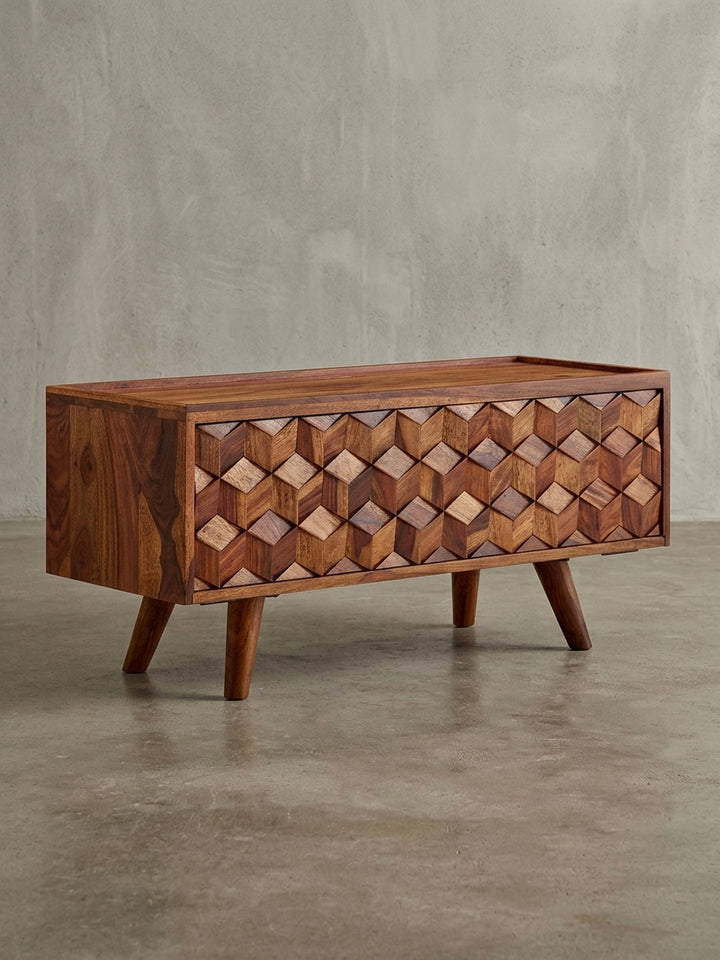 Frontansicht des TV-Lowboards aus Sheesham Massivholz auf weißem Hintergrund. Der 92x44x35 cm große Fernsehschrank zeigt sein geometrisches 3D-Muster in voller Pracht._