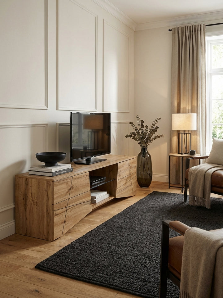 Draufsicht auf ein Wohnzimmer mit einem 160 cm breiten TV-Schrank aus Holz, der auf einem dunklen Teppich steht und die räumliche Anordnung der Möbel zeigt._