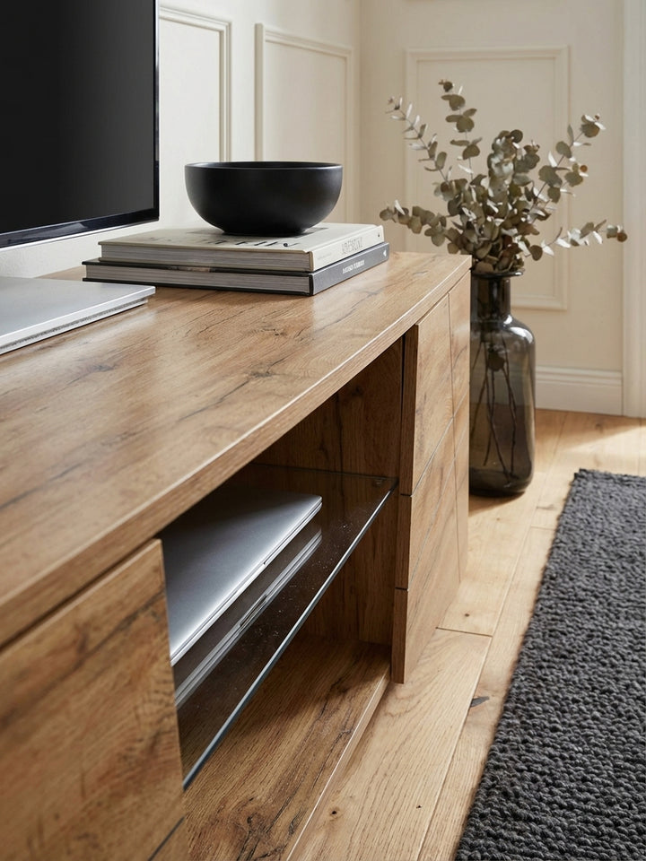 Makroaufnahme der authentischen Holzmaserung eines TV-Schranks in Eichenoptik, die die hochwertige Oberflächenstruktur und die warme Farbe des Materials hervorhebt._