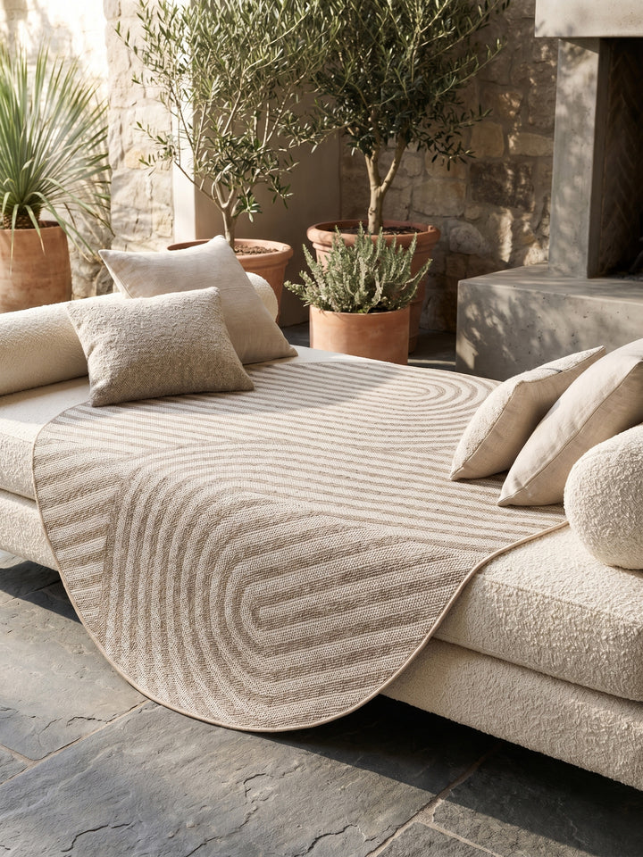 Gemütliche Terrasse mit rundem Outdoor-Teppich, Hängesessel und Lichterketten_