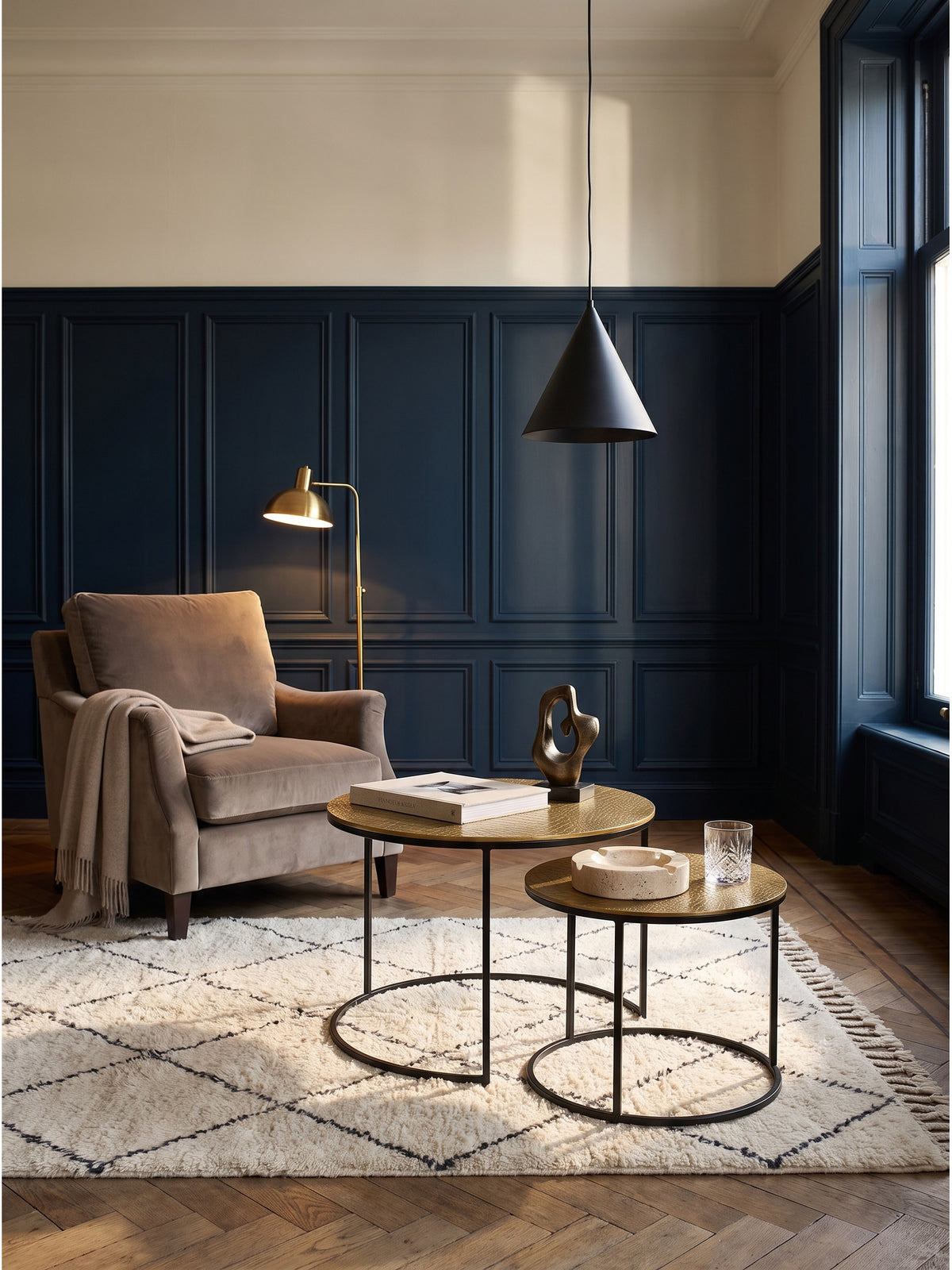 Elegantes 2er Set Satztisch aus Metall mit goldener Aluminium-Tischplatte im modernen Wohnzimmer vor mitternachtsblauer Wand._