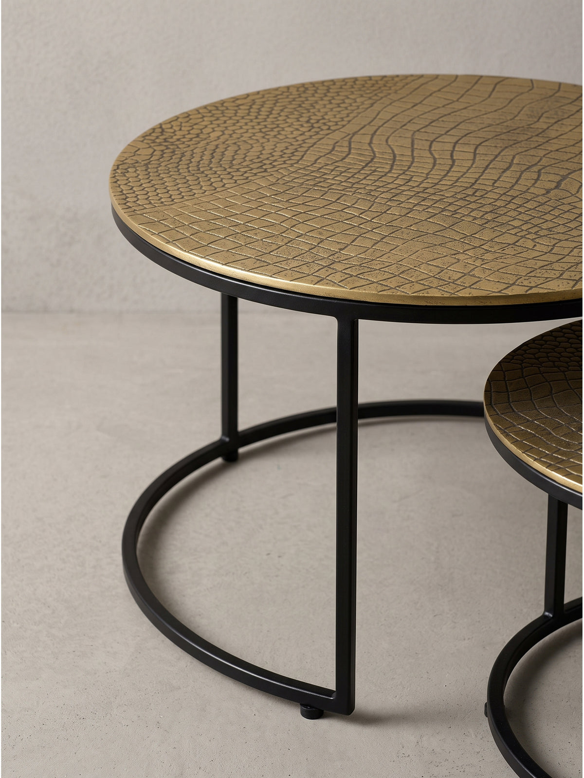 Erhöhte Perspektive auf das 2er Set Satztisch mit seinen edlen, handgefertigten Aluminiumplatten in goldener Ausführung._