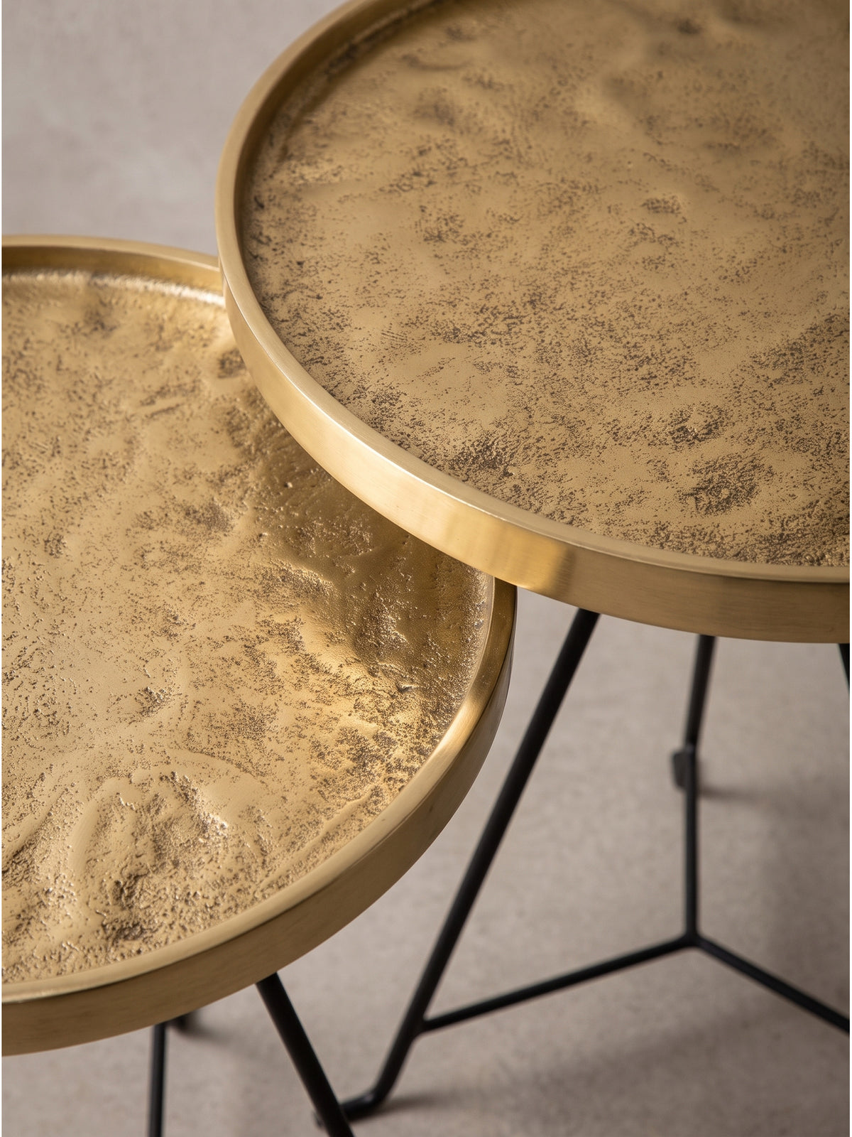 Harmonisches Gesamtbild der beiden industriell inspirierten Couchtische, bei denen goldenes Metall auf schwarzes Eisen trifft.