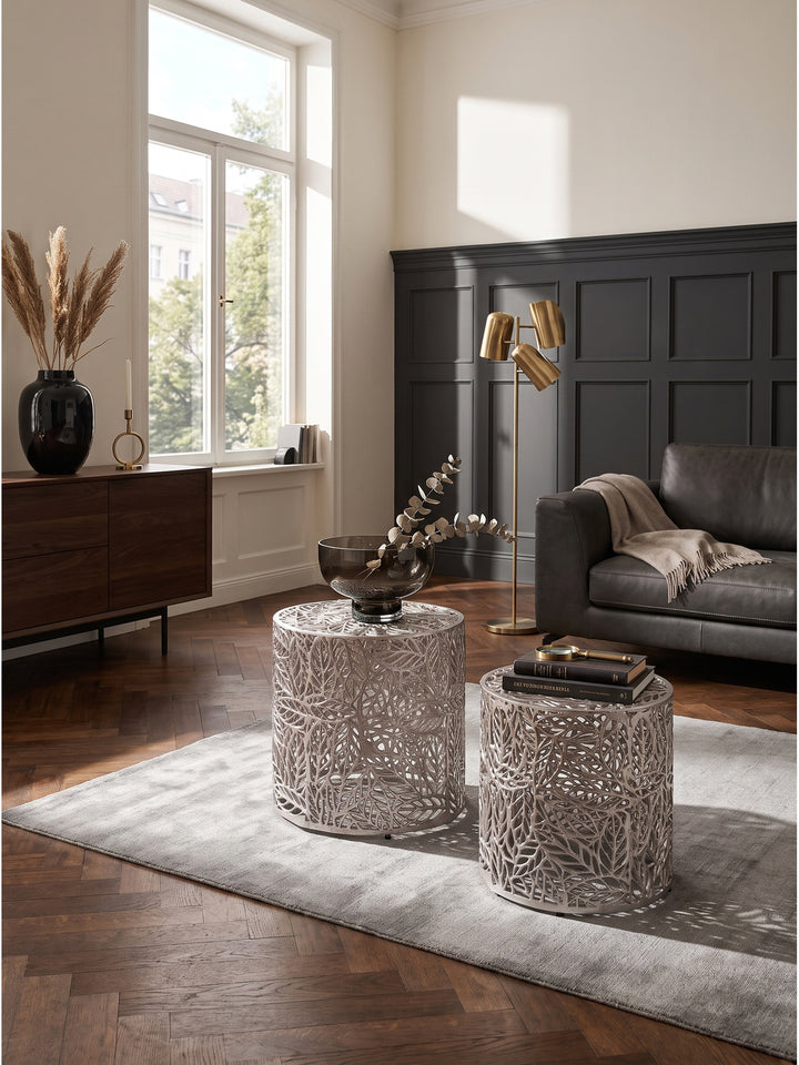 Satztisch 2er Set aus Aluminium in Silber mit dekorativem Blattmuster im eleganten Wohnzimmer auf dunklem Walnussparkett_